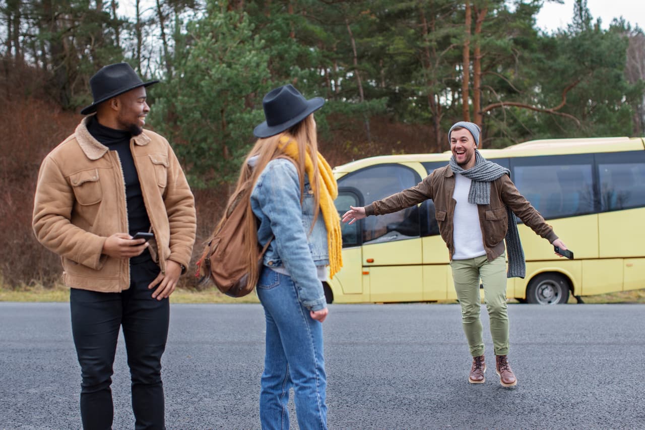 Travellers meeting beside a yellow intercity bus